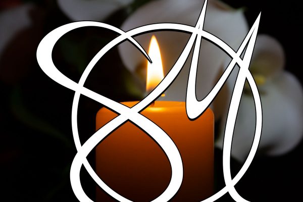 White Sosebee Mortuary logo in front of lit candle with dark background.