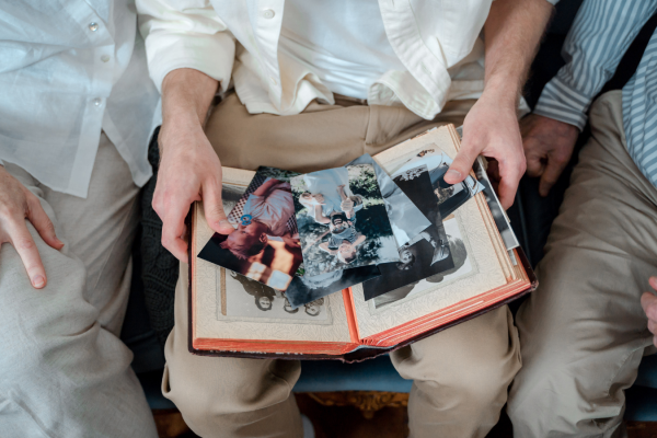 Three people gathered around a memorial book, looking at photos and remembering a loved one.