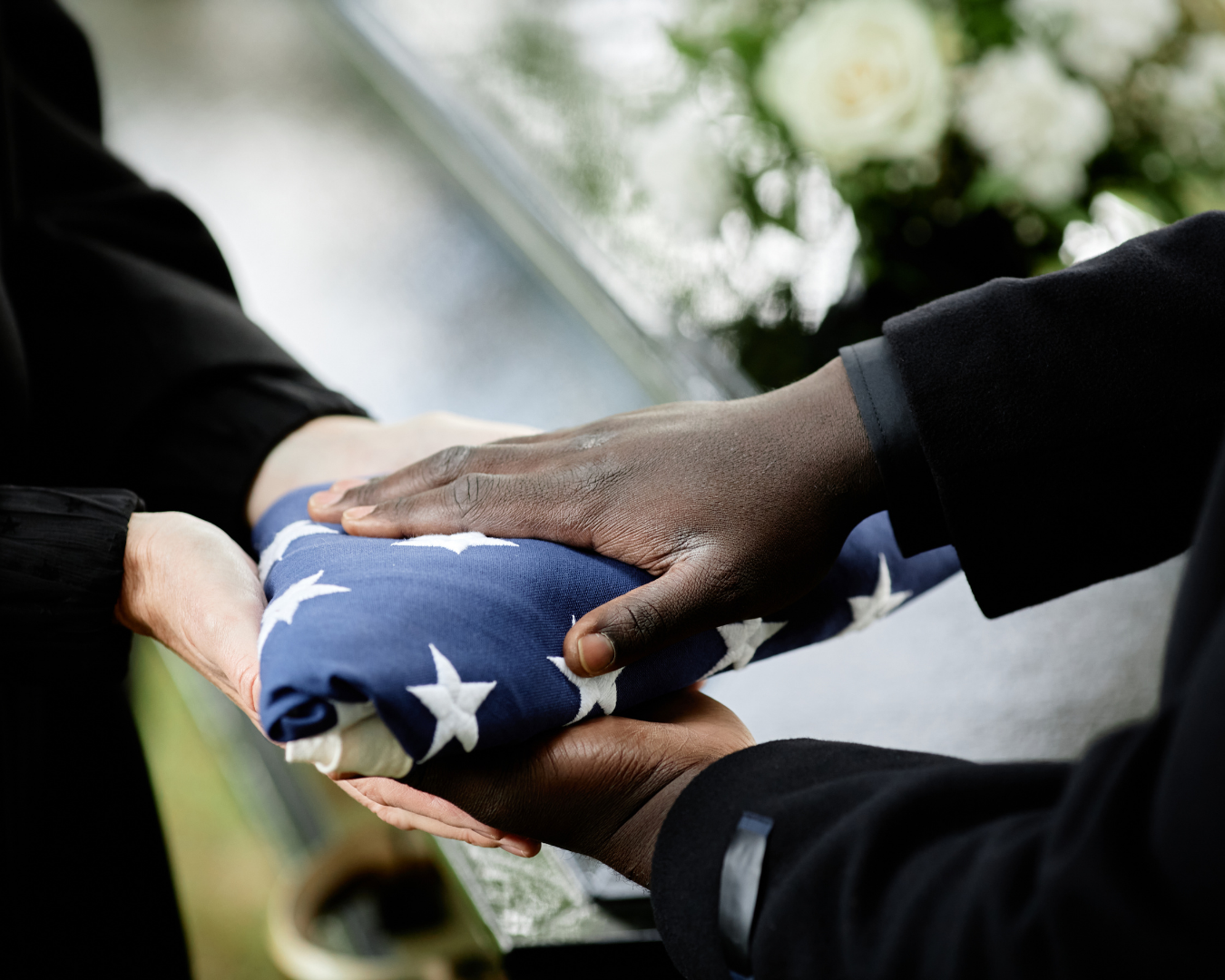 A folded American flag being respectfully handed to a family member during a military funeral ceremony, symbolizing honor and gratitude for a veteran’s service.