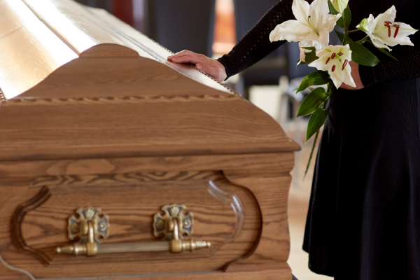 Funeral service scene with wooden casket and white lilies at South Carolina funeral home